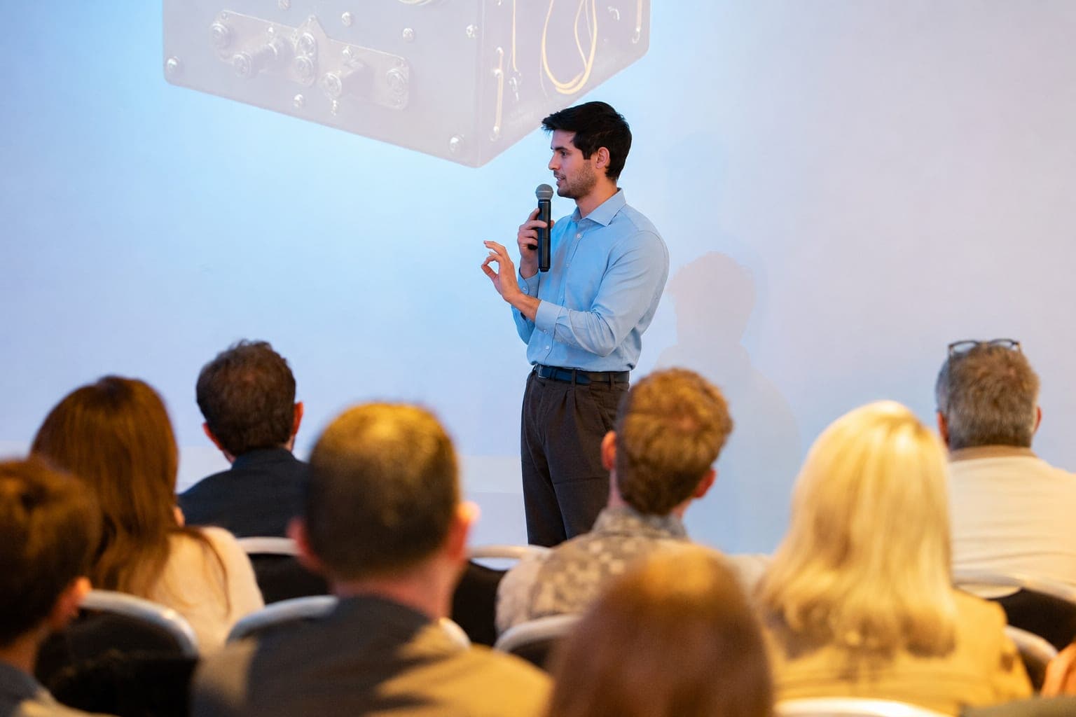 Valentin Brel speaking with a microphone in front of an audience